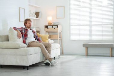 Evdeki kanepede oturan adam, mesaj için yer var.