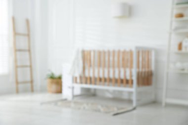 Şık bir beşiği olan bebek odasının bulanık görüntüsü