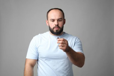 Kellik sorunu. Gri arka planda saçı dökülmüş endişeli bir adam.