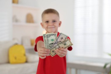 Evde cep harçlığı tutan küçük çocuk, seçici odaklı.