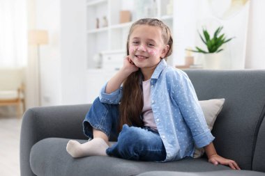 Evinde yüzüne çiçek çizen tatlı bir kız.