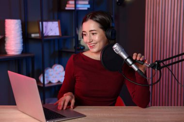 Podcast sunucusu stüdyoda talk show kaydediyor.