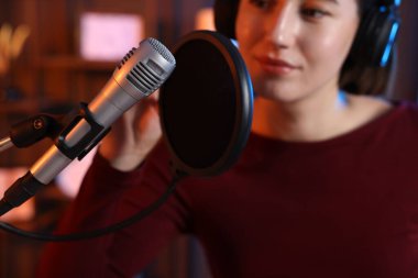 Podcast sunucusu stüdyoda talk show kaydediyor, seçici odak