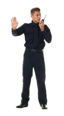 Üniformalı genç bir polis telsiziyle beyaz arka planda dur işareti gösteriyor.