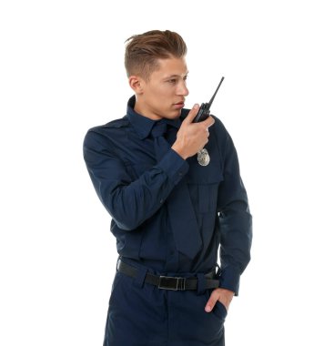 Beyaz arka planda telsizi olan üniformalı genç bir polis.