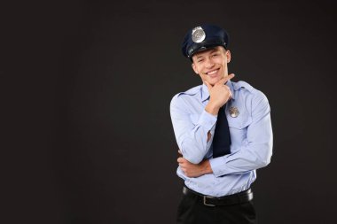 Siyah arka planda üniformalı genç polis, mesaj için boşluk