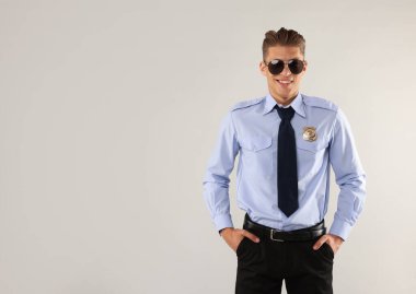 Açık gri arka planda üniformalı genç polis, metin için boşluk