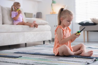 Evde telsiz oyuncaklarıyla oynayan küçük kızlar, seçici odaklanma.