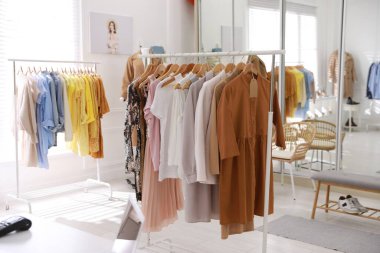 Modern butikte şık kadın kıyafetleri askıda.