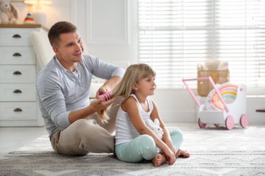 Baba evde kızının saçını tarıyor, mesaj atmak için yer açıyor.