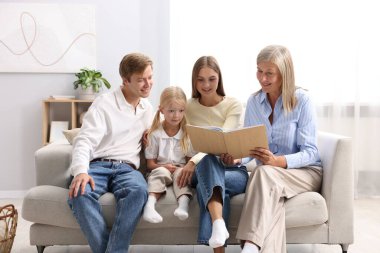 Son sınıf öğrencisi, oğlunun ailesiyle birlikte fotoğraf albümüne bakıyor.