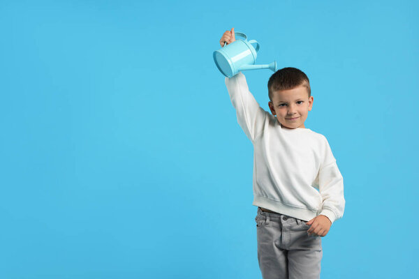 Маленький мальчик с лейкой банкой на голубом фоне. Пространство для текста