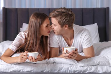 Hoş bir çift evde sıcak içeceklerin tadını çıkarıyor.