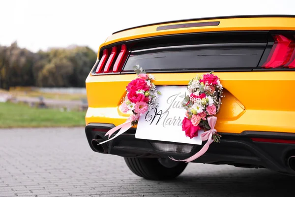 Düğün arabası. Cabriolet dekore edilmiş. Sadece evlilik kartı ve açık havada güzel çiçekler, yakın plan.