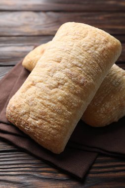 Yeni pişmiş ciabatalar ahşap masada, yakın plan.
