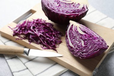 Cut fresh red cabbage and knife on light table, closeup