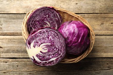 Taze kırmızı lahanaları hasır sepetin içinde ahşap masanın üstünde, üst tarafta.