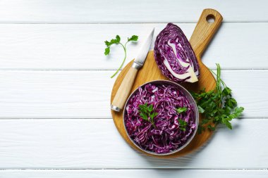 Beyaz ahşap masada kırmızı lahana, maydanoz ve bıçak kes. Metin için boşluk