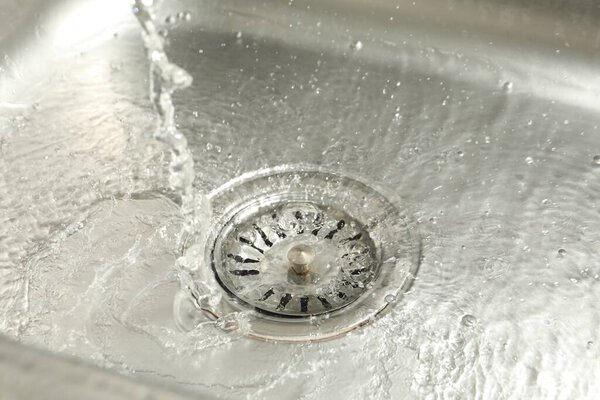 Water going down sink drain, closeup view