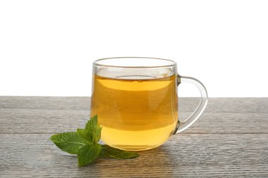 Aromatic tea with lemon in cup and mint on wooden table against white background