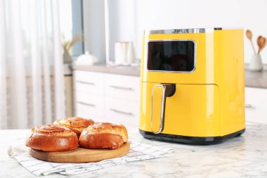 Mutfaktaki beyaz mermer masada taze pişmiş çörekler.