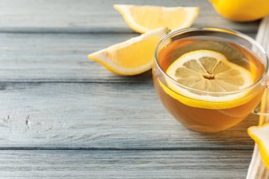 Aromatik çay bardakta, ahşap masada limon, yakın plan. Metin için boşluk