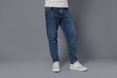 Gri arka planda şık kotlu adam, yakın plan.