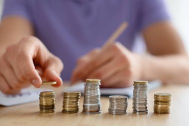 İçerideki ahşap masada madeni paraları sayan adam, seçici odaklanma