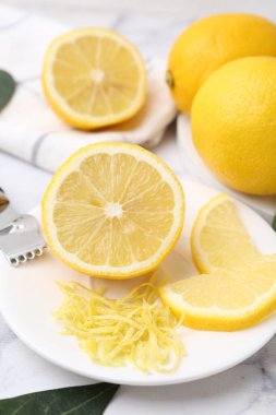 Lemon zest, fresh fruits and zester tool on table, closeup