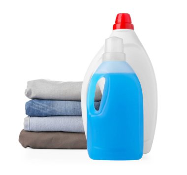 Bottles of laundry detergent and stacked clothes isolated on white