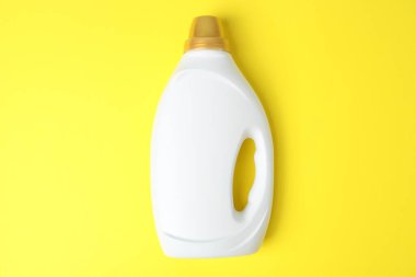 Bottle of fabric softener on yellow background, top view