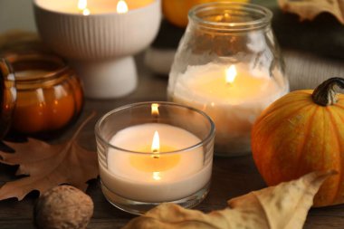 Masada yanan mumlar ve balkabaklarıyla sonbahar kompozisyonu, yakın plan