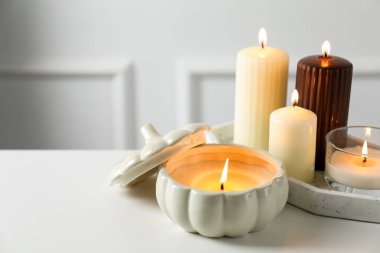 Beyaz masada birçok farklı yanan mum, yakın plan. Metin için boşluk