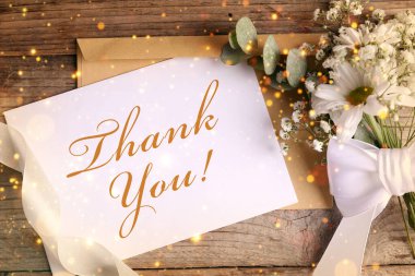 Teşekkür kartı, zarf ve çiçek, ahşap arka plan, üst manzara. Bokeh ışıkları