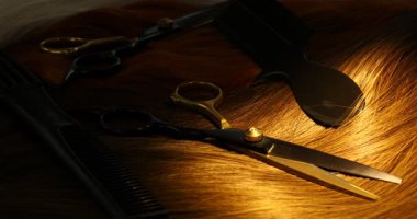 Güzel saç tellerine ve kuaför aletlerine ışık tutmak, yakın çekim..