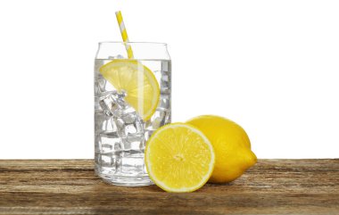 Tahta masadaki limonlu suyu beyaz arkaplana karşı ferahlatıyor