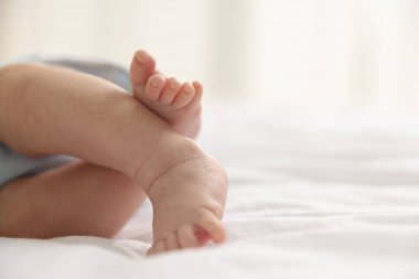 Evdeki yatakta uzanmış şirin küçük bebek, yakın plan. Metin için boşluk