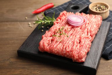 Biberiyeli çiğ et, kekik ve baharatlar ahşap masada, yakın plan.