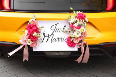 Düğün arabası. Cabriolet dekore edilmiş. Sadece evlilik kartı ve açık havada güzel çiçekler, yakın plan.