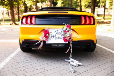 Düğün arabası. Cabriolet sadece evlilik kartıyla dekore edilmiş, güzel çiçekler ve teneke kutular.