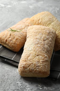 Gri desenli masada taze çıtır ciabatalar, yakın plan.