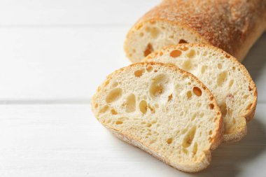 Beyaz ahşap masada çıtır çıtır ciabatta kes, yakın plan. Metin için boşluk