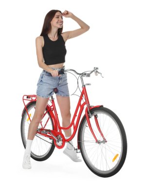 Kırmızı bisiklette beyaz arka planda poz veren gülümseyen kadın.