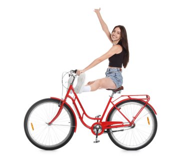 Beyaz arka planda kırmızı bisiklet süren gülümseyen kadın.