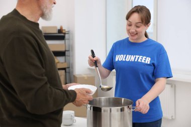 Yaşlılar için insani yardım. Gönüllü içeride kıdemli bir adama yemek veriyor.