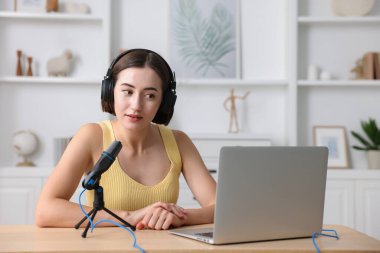 Kapalı mekanda mikrofon ve dizüstü bilgisayarlı Podcast sunucu kayıt bölümü