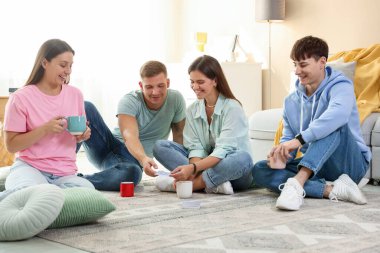 Bir grup arkadaş içeride iskambil oynuyor.