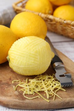 Lemon zest, fresh fruits and zester tool on table, closeup