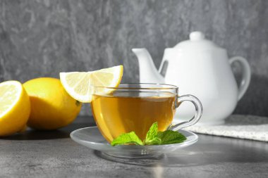 Limonlu, nane ve çaydanlıklı, gri masada, yakın plan Aromatik çay