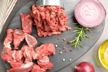 Öğütücüyle kıyma ve baharatla gri masada kıyma yapmak.